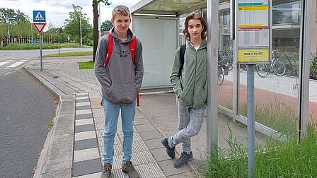 Twee buurjongens reizen met het openbaar vervoer naar school